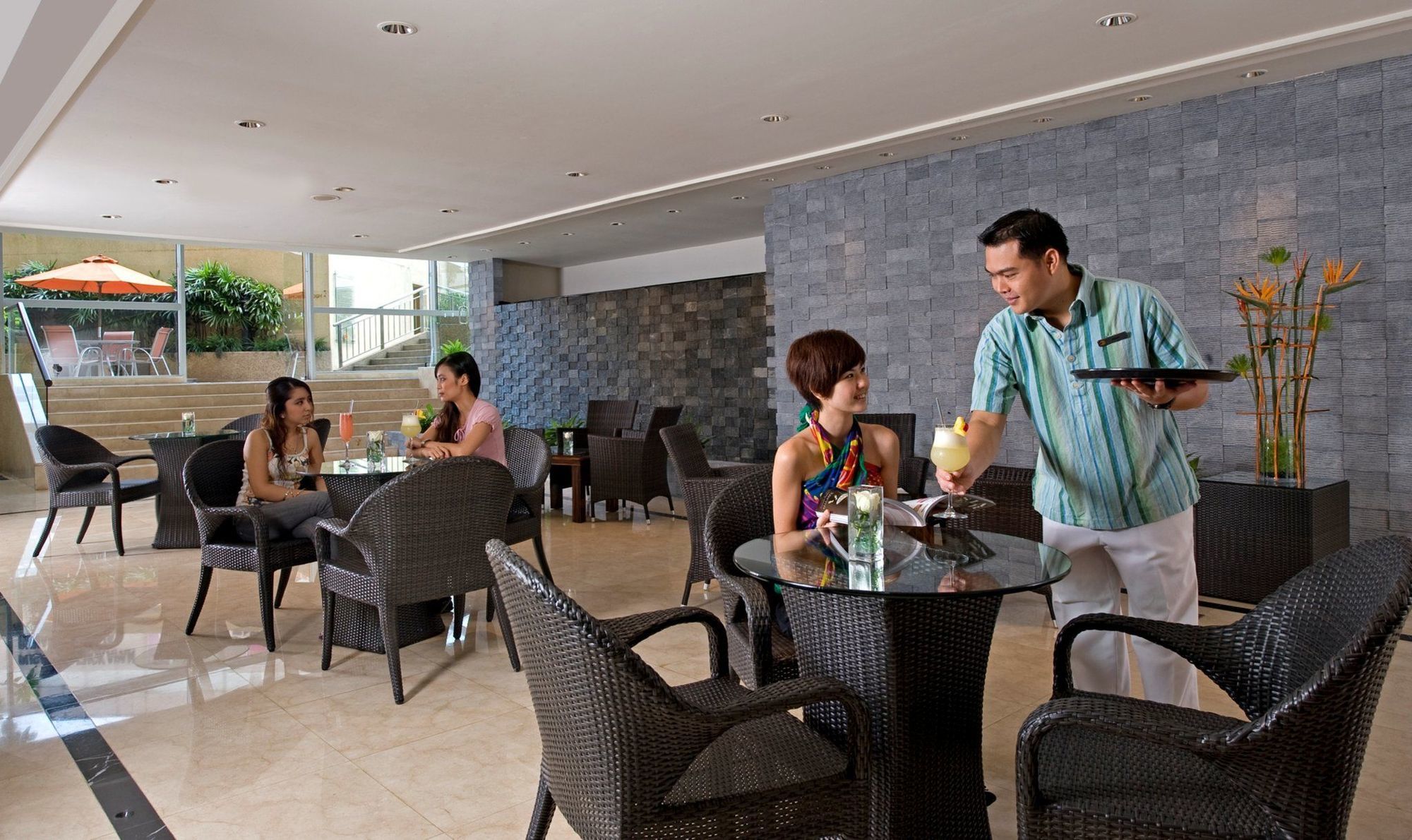 One World Hotel Petaling Jaya Restaurant photo A waiter serving drinks at a restaurant